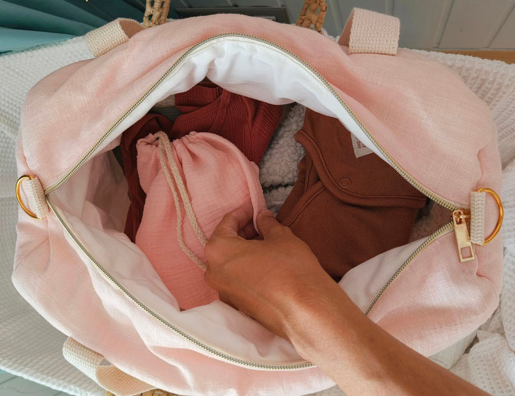 Bolsa de maternidad de lino rosa abierta, con el neceser a juego