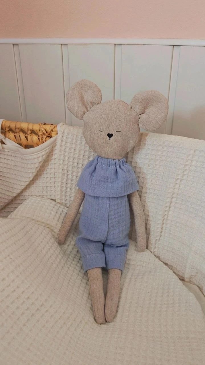 Ratoncito de peluche artesanal con ropita de muselina azul, sentado en la cuna