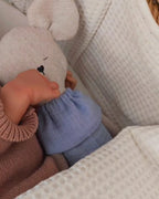 Bebé abrazando al ratoncito de peluche en la cuna